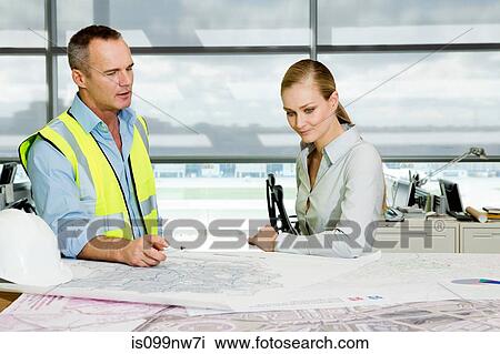Engineer with architect looking at blueprints in office View Large Photo Image Stock Image - Engineer with architect looking at blueprints in office. Fotosearch