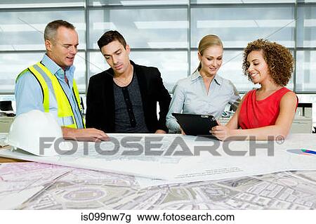 Engineer with architects looking at blueprints and digital tablet in office View Large Photo Image Stock Image - Engineer with architects looking at blueprints and digital tablet in office. Fotosearch