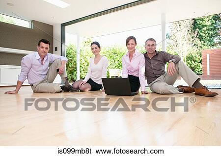 Four businesspeople sitting on floor, portrait View Large Photo Image Stock Photograph - Four businesspeople sitting on floor, portrait. Fotosearch