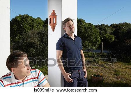 Gay couple relaxing in sun outside apartment View Large Photo Image Stock Image - Gay couple relaxing in sun outside apartment. Fotosearch