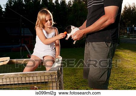Stock Image - Girl feeding guinea pig. Fotosearch