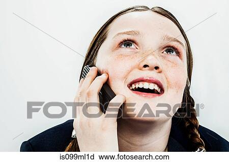 Stock Image - Girl on cell phone, looking up. Fotosearch