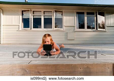 Girl on porch, reading electronic book View Large Photo Image Stock Image - Girl on porch, reading electronic book. Fotosearch