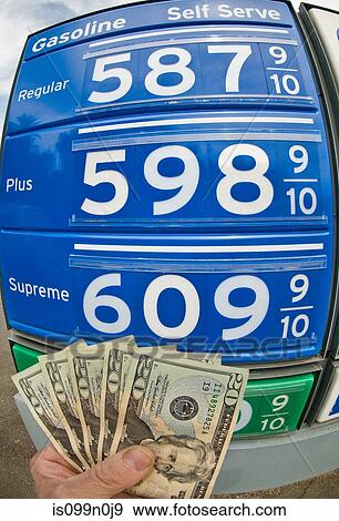 Hand holding dollar bills at gas station in Death Valley National Park, California, USA View Large Photo Image Stock Photo - Hand holding dollar bills at gas station in Death Valley National Park, California, USA. Fotosearch