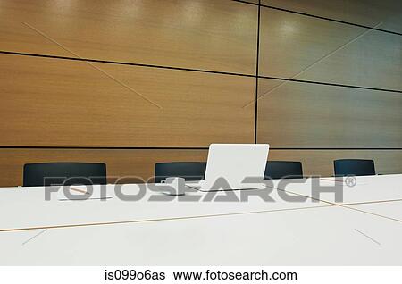 Stock Photograph - Laptop on conference table in empty office block. Fotosearch