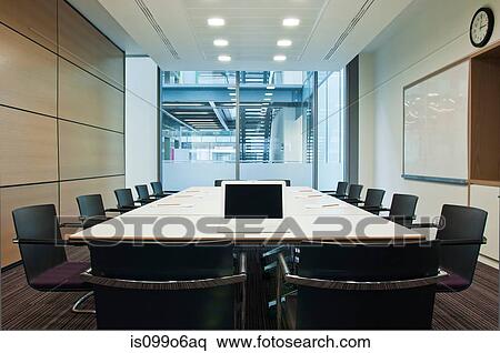 Stock Photography - Laptop on conference table in empty office block. Fotosearch