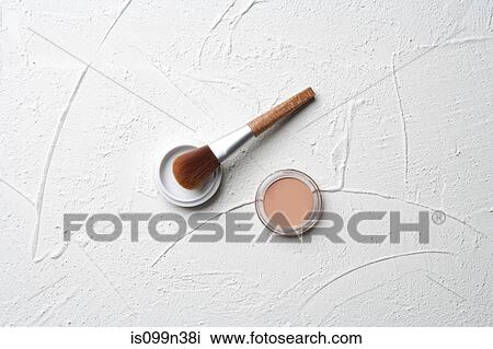 Stock Image - Make up and brush on plaster background. Fotosearch