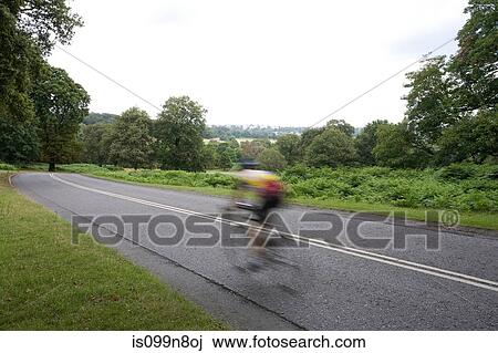 Man cycling on road in Richmond Park, London, UK View Large Photo Image Stock Image - Man cycling on road in Richmond Park, London, UK. Fotosearch