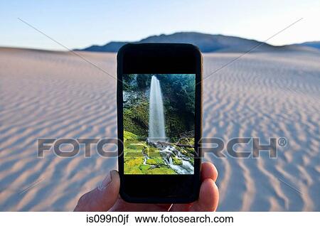 Man holding cellphone with waterfall image in Death Valley National Park, California, USA View Large Photo Image Stock Image - Man holding cellphone with waterfall image in Death Valley National Park, California, USA. Fotosearch