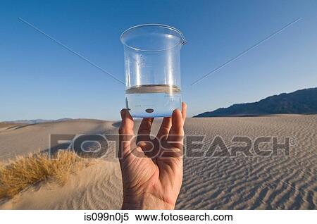Man holding water in beaker in Death Valley National Park, California, USA View Large Photo Image Stock Photography - Man holding water in beaker in Death Valley National Park, California, USA. Fotosearch