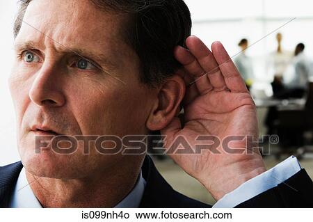 Mature businessman eavesdropping on colleagues View Large Photo Image Picture - Mature businessman eavesdropping on colleagues. Fotosearch