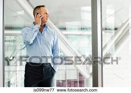 Mature businessman in office using cellphone View Large Photo Image Stock Photo - Mature businessman in office using cellphone. Fotosearch