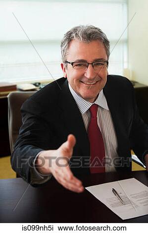 Mature businessman shaking hands at job interview View Large Photo Image Stock Image - Mature businessman shaking hands at job interview. Fotosearch