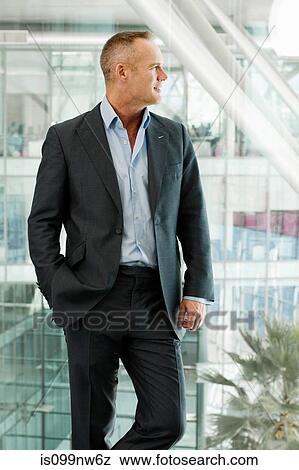 Stock Photo - Mature businessman standing in office. Fotosearch