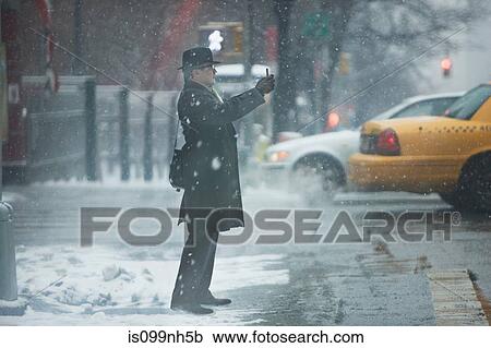 Stock Image - Mature man hailing cab in city. Fotosearch