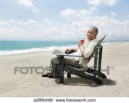 Mature man relaxing in chair on beach View Large Photo Image Stock Image - Mature man relaxing in chair on beach. Fotosearch