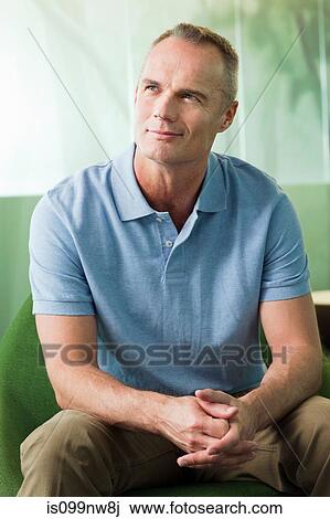 Mature man sitting in green chair in office View Large Photo Image Stock Image - Mature man sitting in green chair in office. Fotosearch