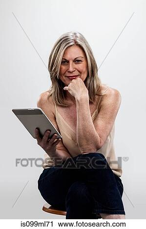 Mature woman holding digital tablet View Large Photo Image Stock Image - Mature woman holding digital tablet. Fotosearch