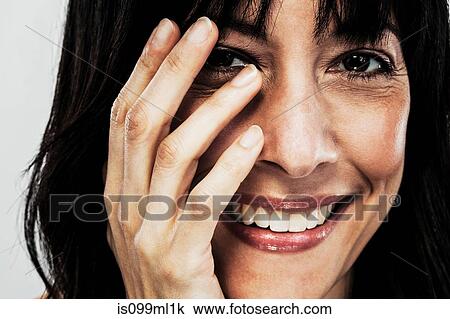 Stock Image - Mature woman touching face. Fotosearch