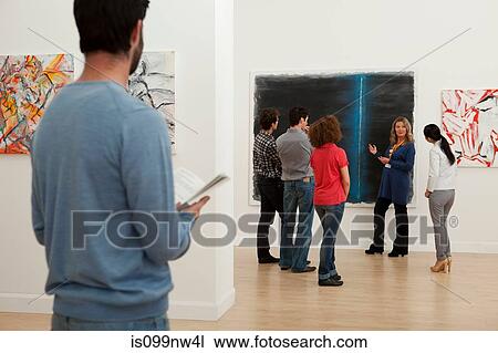 Men and women listening to guide in art gallery View Large Photo Image Stock Image - Men and women listening to guide in art gallery. Fotosearch