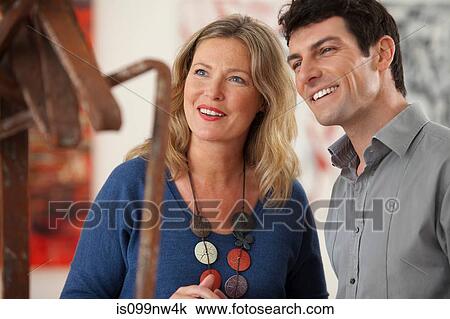 Stock Image - Mid adult couple looking at sculpture in art gallery. Fotosearch