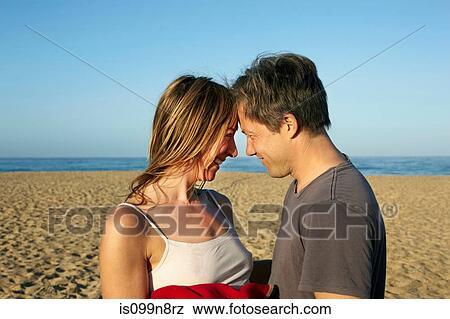 Mid adult couple relaxing head to head on beach View Large Photo Image Stock Photo - Mid adult couple relaxing head to head on beach. Fotosearch