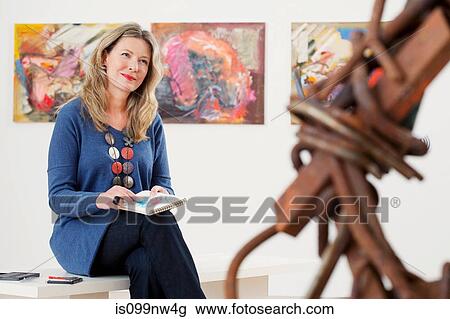 Mid adult woman drawing in sketch pad in art gallery View Large Photo Image Stock Image - Mid adult woman drawing in sketch pad in art gallery. Fotosearch