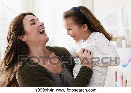 Mid adult woman holding daughter, smiling View Large Photo Image Stock Photography - Mid adult woman holding daughter, smiling. Fotosearch