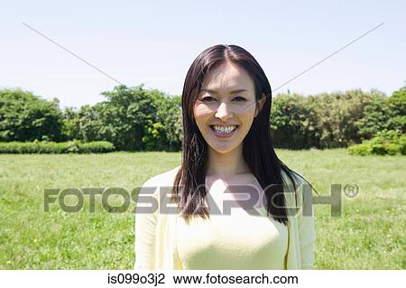 Stock Image - Mid-adult woman in a field. Fotosearch