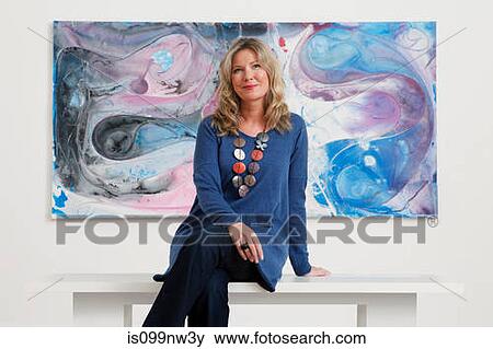 Mid adult woman sitting in front of oil painting in gallery View Large Photo Image Stock Photo - Mid adult woman sitting in front of oil painting in gallery. Fotosearch