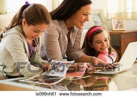 Mother and two daughters using laptop at home View Large Photo Image Stock Image - Mother and two daughters using laptop at home. Fotosearch