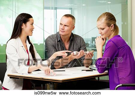 Office colleagues discussing new technologies on desk View Large Photo Image Stock Photo - Office colleagues discussing new technologies on desk. Fotosearch