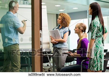 Stock Photograph - Office colleagues in whiteboard meeting in office. Fotosearch
