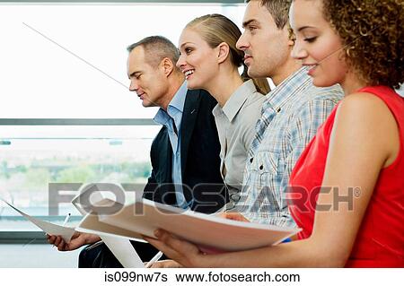 Office colleagues reading documents in office View Large Photo Image Stock Photograph - Office colleagues reading documents in office. Fotosearch
