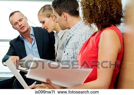 Office colleagues reading documents in office View Large Photo Image Stock Photograph - Office colleagues reading documents in office. Fotosearch