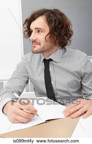 Office worker writing in notebook View Large Photo Image Stock Photo - Office worker writing in notebook. Fotosearch