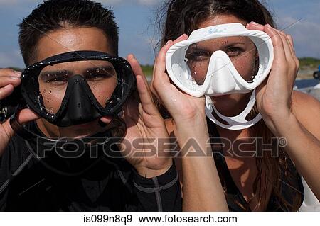 Stock Photo - Playful Couple with Face Masks. Fotosearch