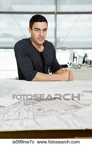 Portrait of an architect working on blueprints in office View Large Photo Image Picture - Portrait of an architect working on blueprints in office. Fotosearch