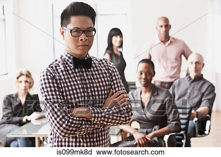 Portrait of businessman with colleagues in background View Large Photo Image Stock Image - Portrait of businessman with colleagues in background. Fotosearch
