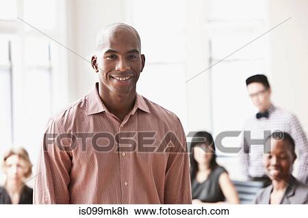 Portrait of businessman with colleagues in background View Large Photo Image Stock Image - Portrait of businessman with colleagues in background. Fotosearch