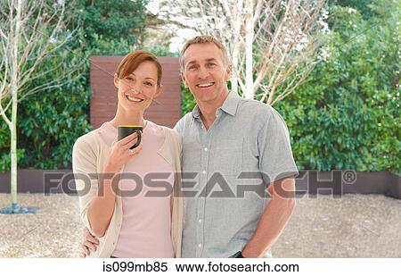 Stock Photography - Portrait of couple, woman holding mug. Fotosearch