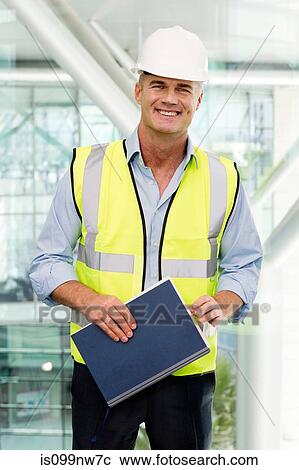 Portrait of engineer wearing hard hat in office View Large Photo Image Stock Image - Portrait of engineer wearing hard hat in office. Fotosearch