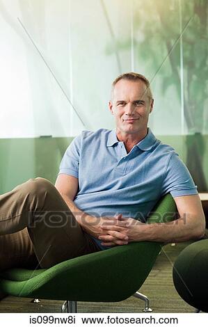 Portrait of mature man sitting in green chair in office View Large Photo Image Stock Image - Portrait of mature man sitting in green chair in office. Fotosearch