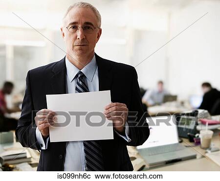 Stock Image - Portrait of senior man holding blank sheet of paper. Fotosearch