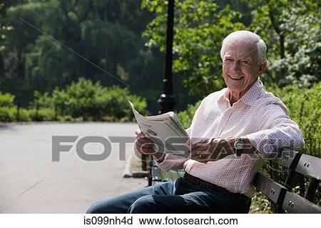 Portrait of senior man reading newspaper, smiling View Large Photo Image Stock Image - Portrait of senior man reading newspaper, smiling. Fotosearch