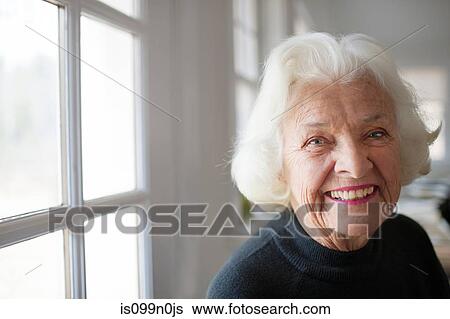 Stock Photograph - Portrait of senior woman by window. Fotosearch