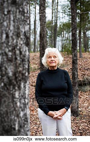 Portrait of senior woman in forest, hands clasped View Large Photo Image Stock Photo - Portrait of senior woman in forest, hands clasped. Fotosearch