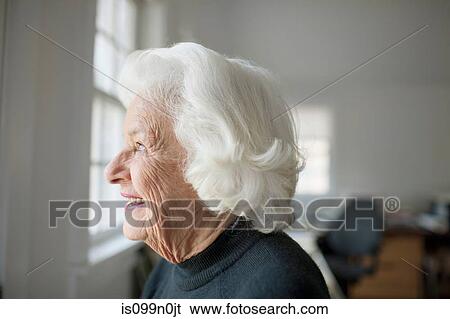 Portrait of senior woman looking out of window View Large Photo Image Stock Photograph - Portrait of senior woman looking out of window. Fotosearch