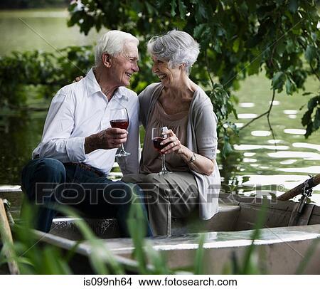 Senior couple drinking wine on rowing boat View Large Photo Image Picture - Senior couple drinking wine on rowing boat. Fotosearch