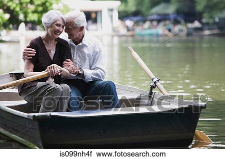 Stock Image - Senior couple embracing in rowing boat. Fotosearch